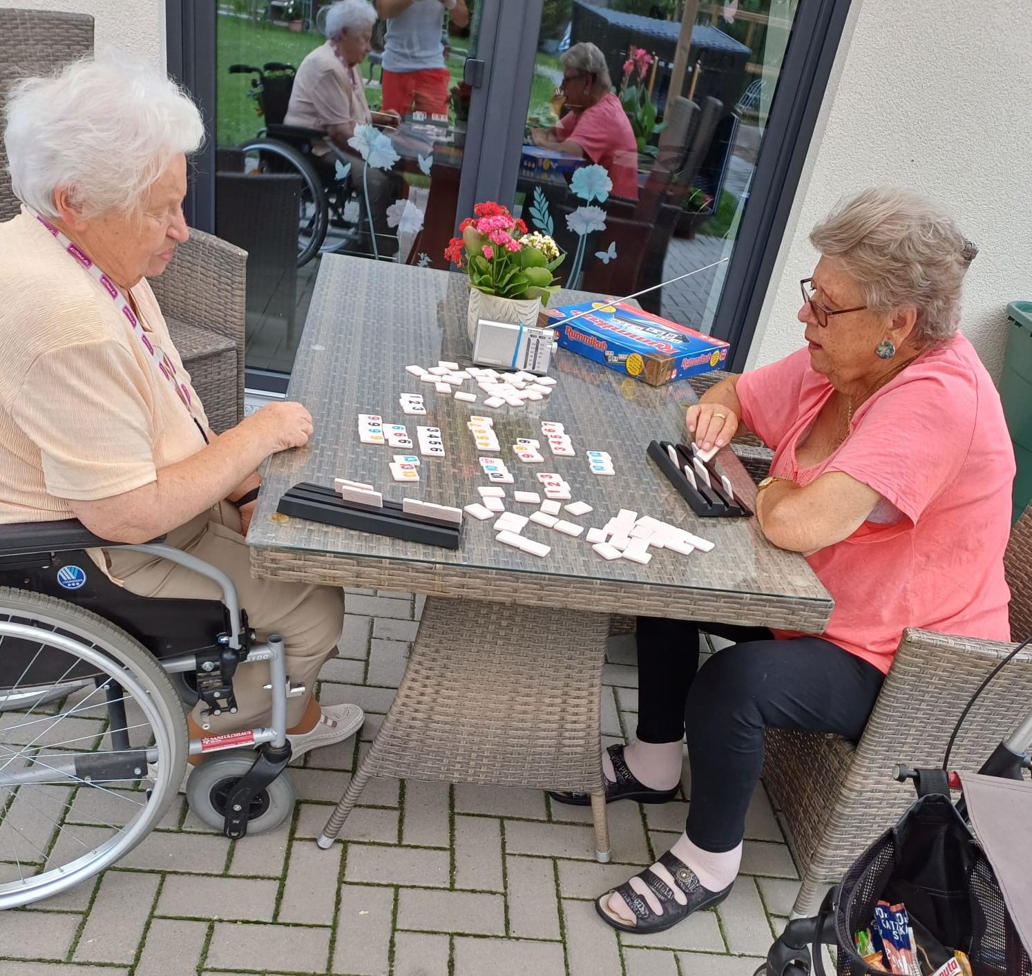2 Bewohnerinnen der Wohngemeinschaft sitzen am Tisch und spielen Rommekub.